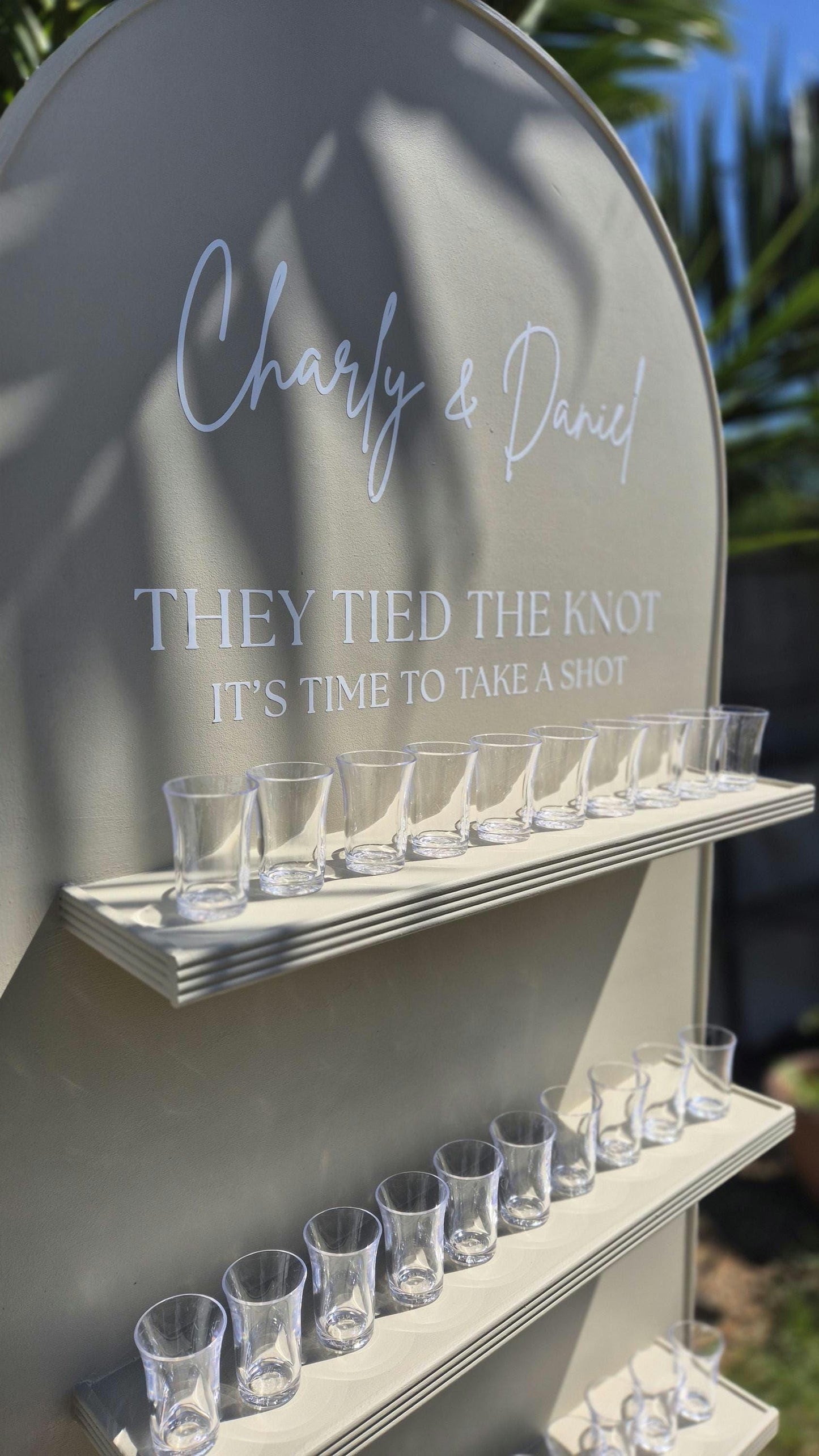 close up of the top section of a wedding wall, showing the graphics on the wall "They tied the knot its time to take a shot"