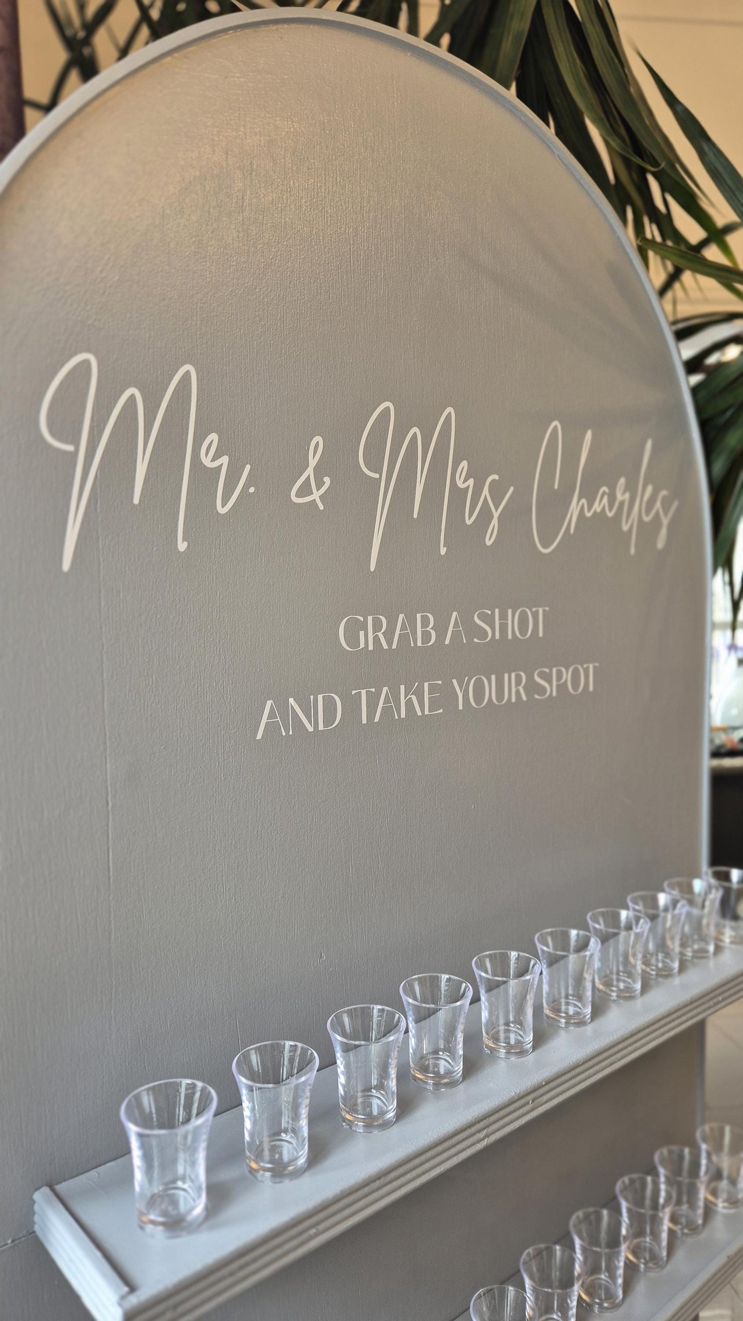 close up of the top section of a wedding wall, showing the graphics on the wall "They tied the knot its time to take a shot"
